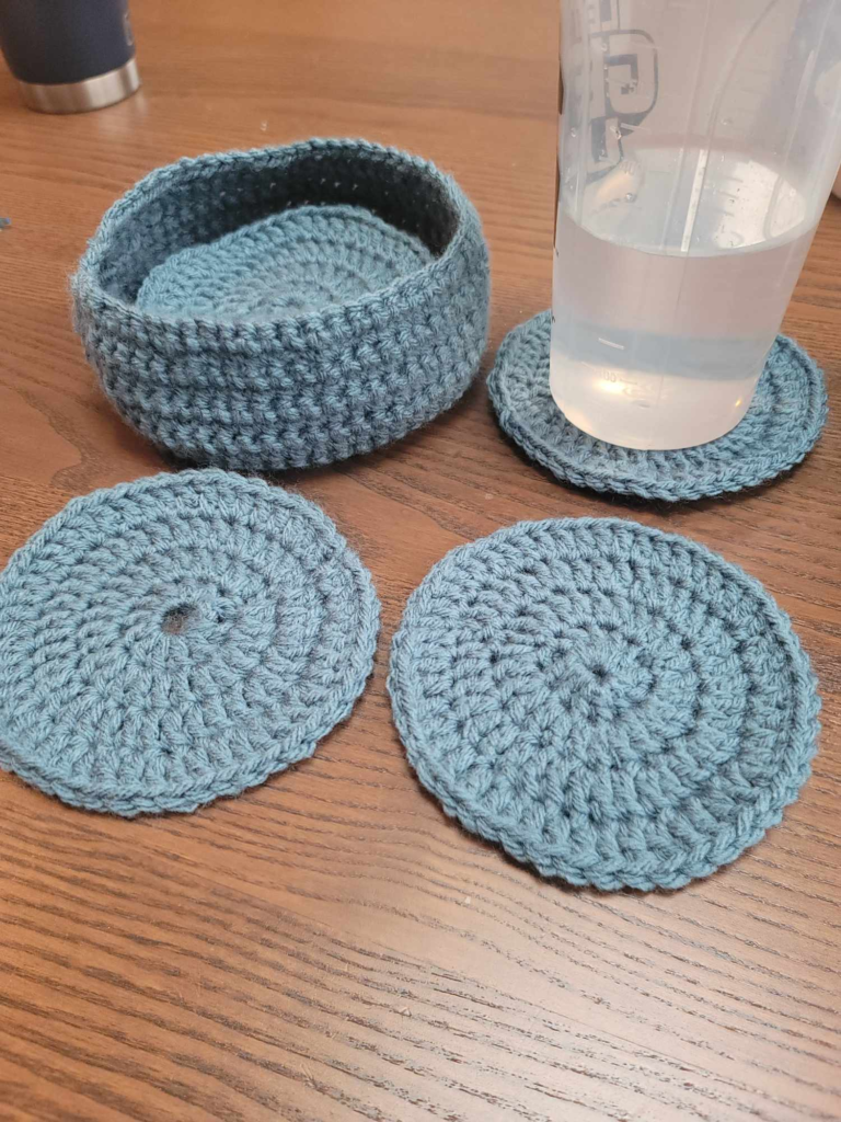 Crocheted coasters in blue circles with a matching blue open container