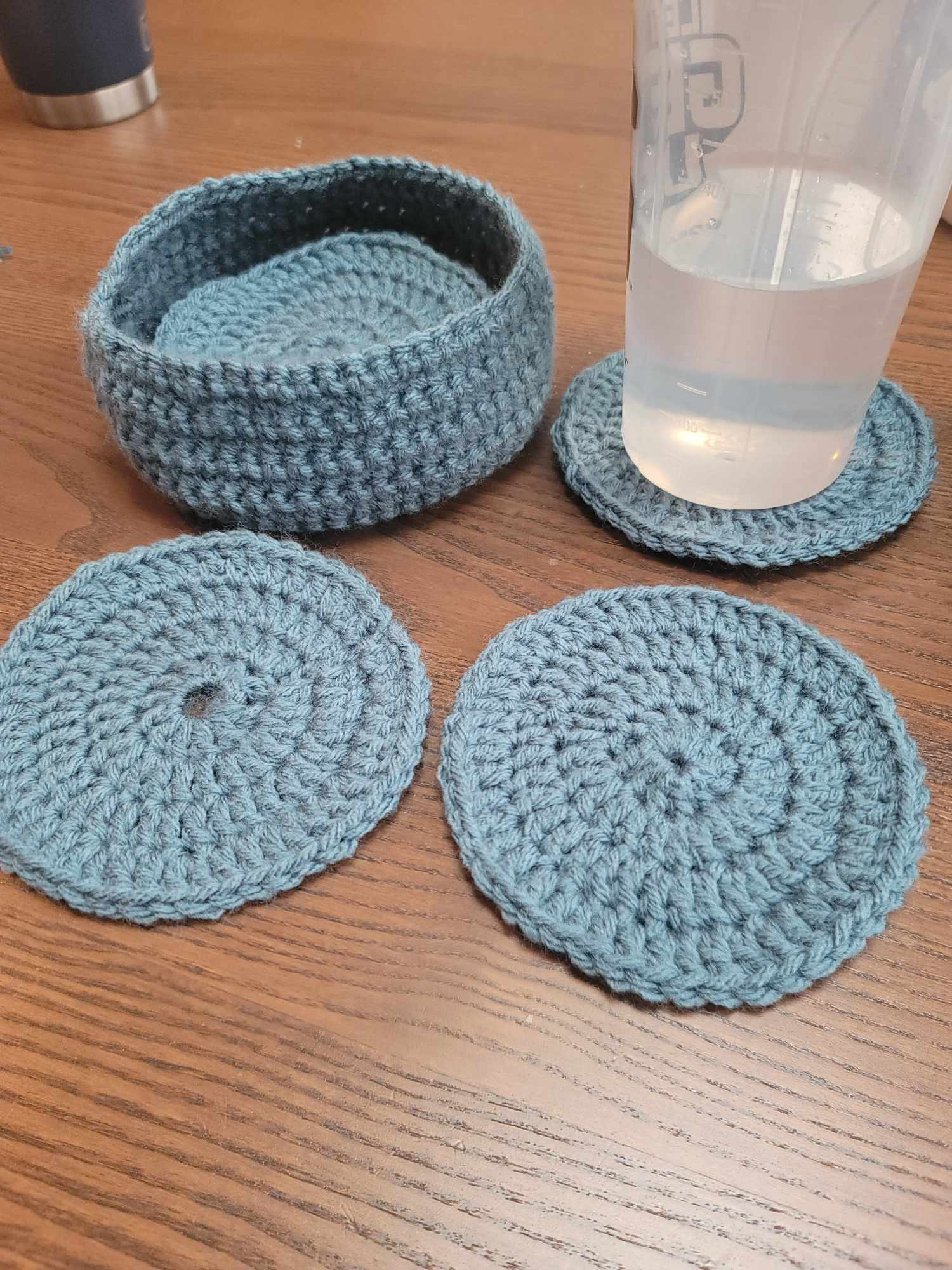 Crocheted coasters in blue circles with a matching blue open container