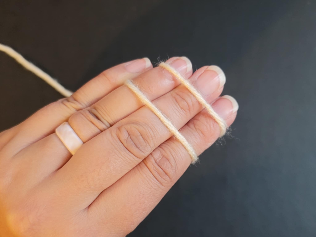 picture of back of hand with 2 parallel yarn strands showing