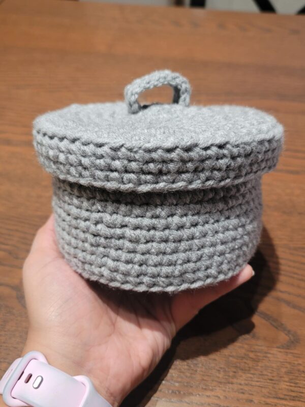 Gray crochet scrap bin with lid that is easily held in one hand