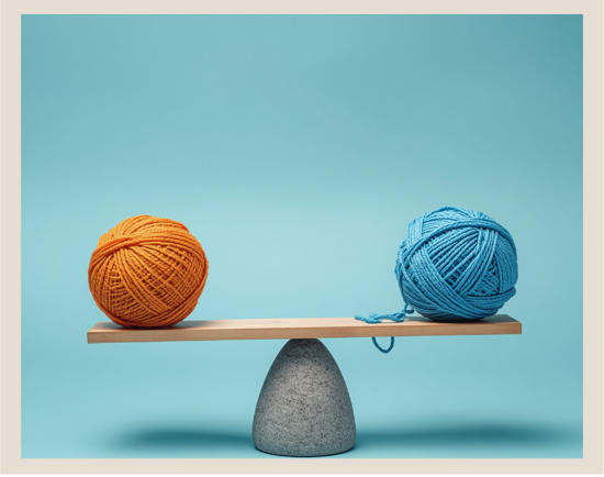 a wooden board balancing on a rock with 1 yarn skein on each end.